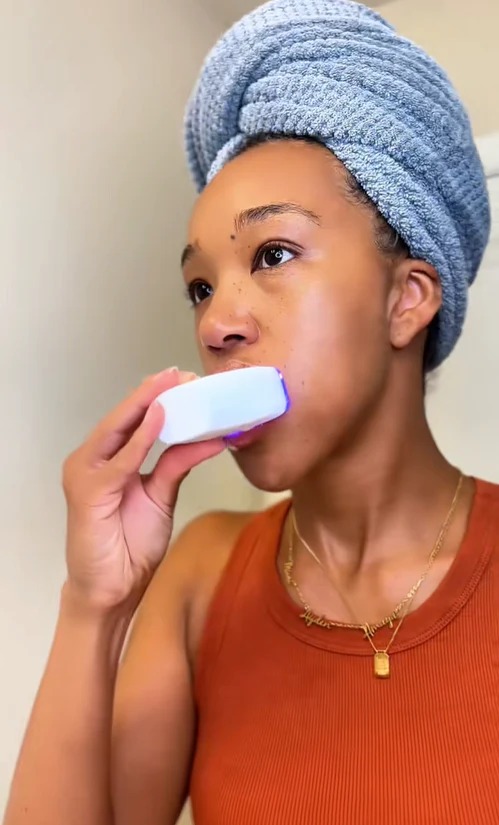 Woman using 360° Sonic Electric Toothbrush